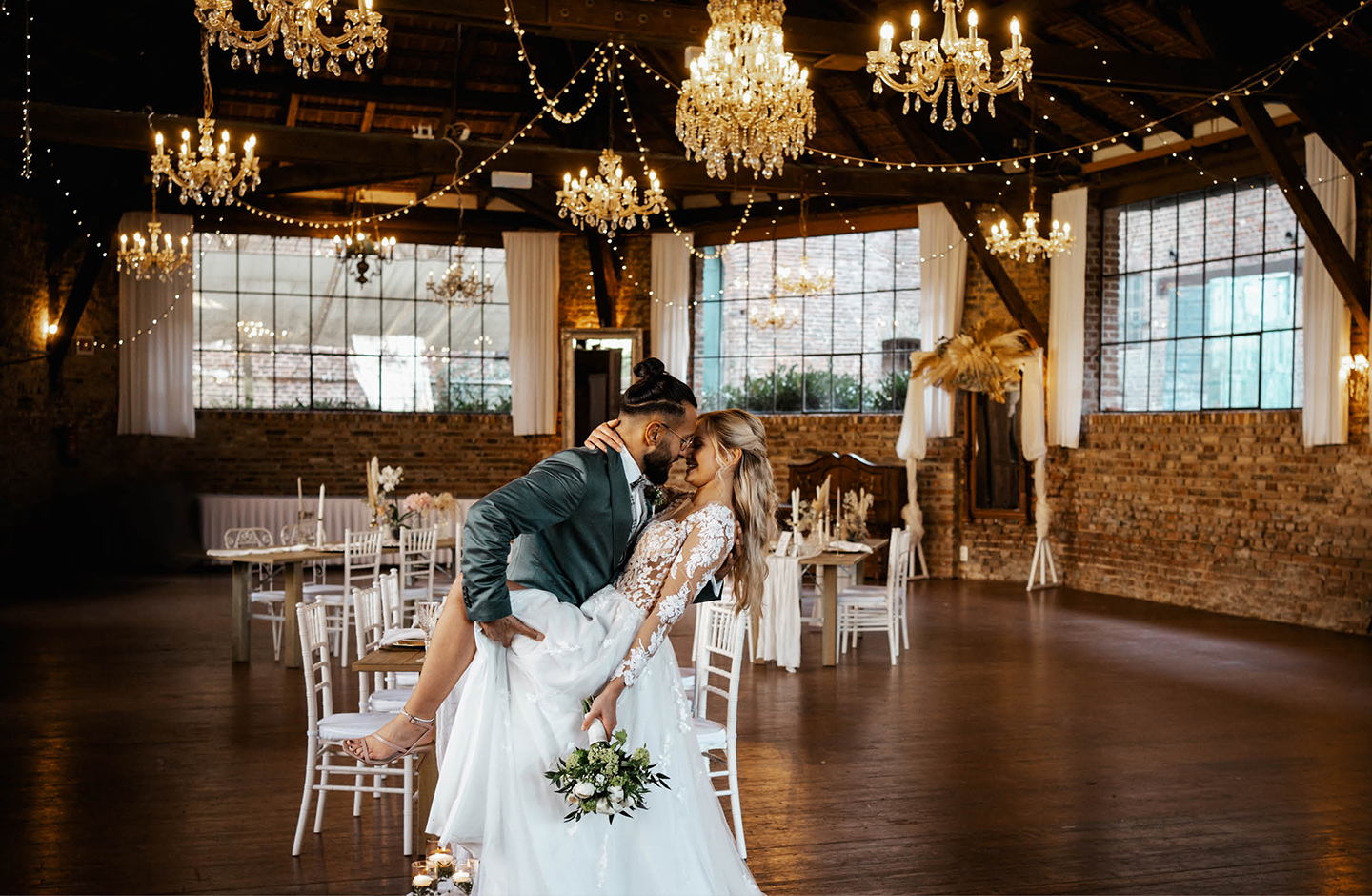  Braut und Bräutigam tanzen in der geschmückten, rustikalen Hochzeitslocation.
