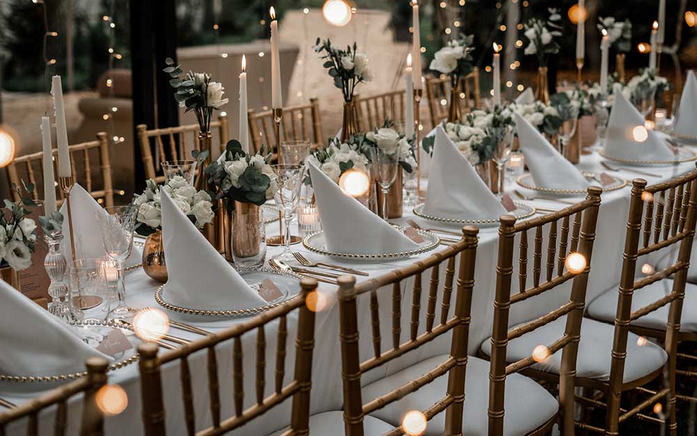 Hochzeitdeko Checkliste Tisch ist mit Kerzen Blumen und Sukkulenten dekoriert.