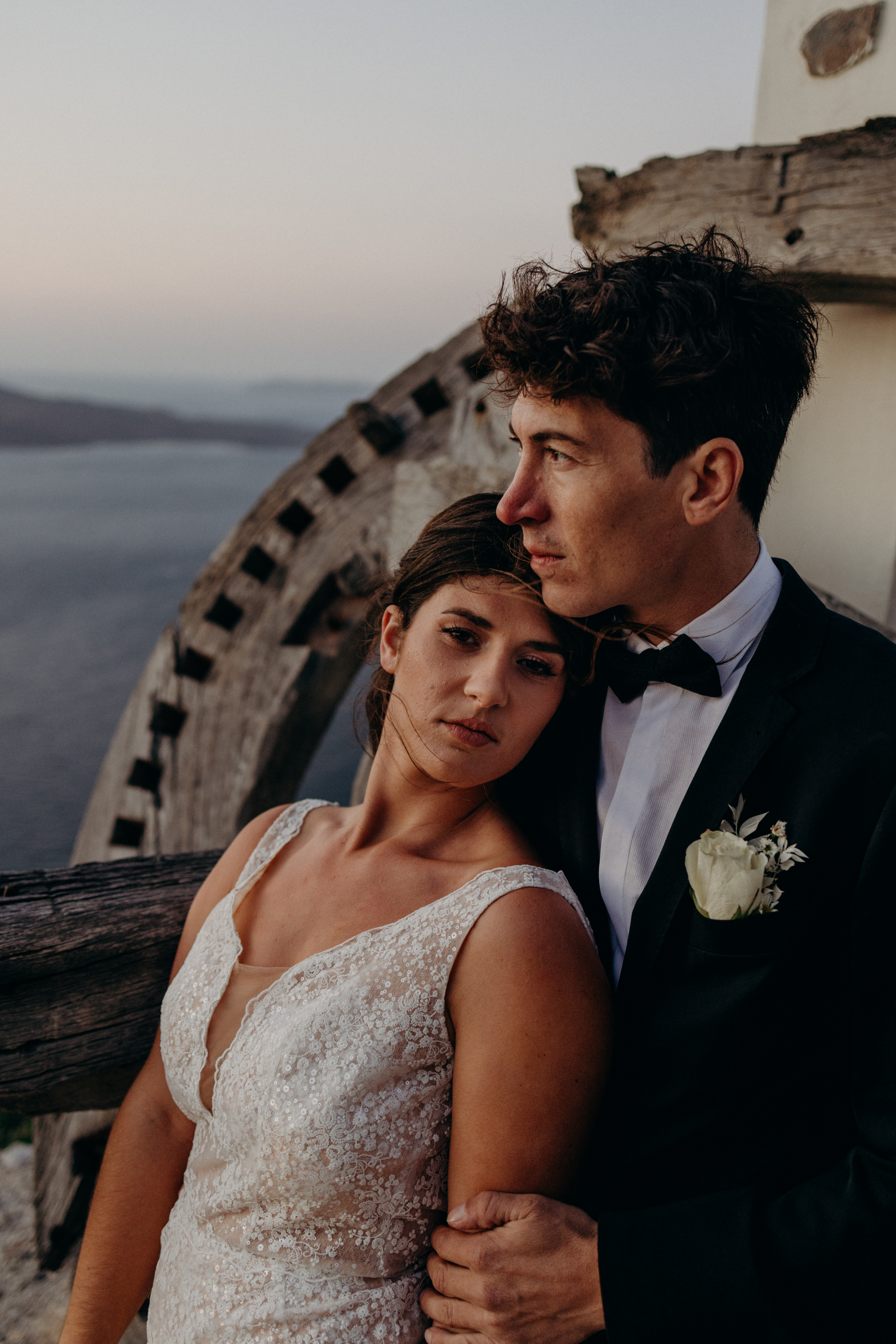 Braut und Bräutigam blicken auf das Meer vor Santorini.