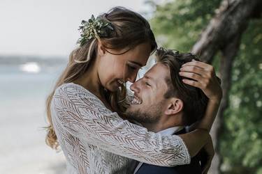 Glückliches Hochzeitspaar umarmt sich zärtlich am Seeufer