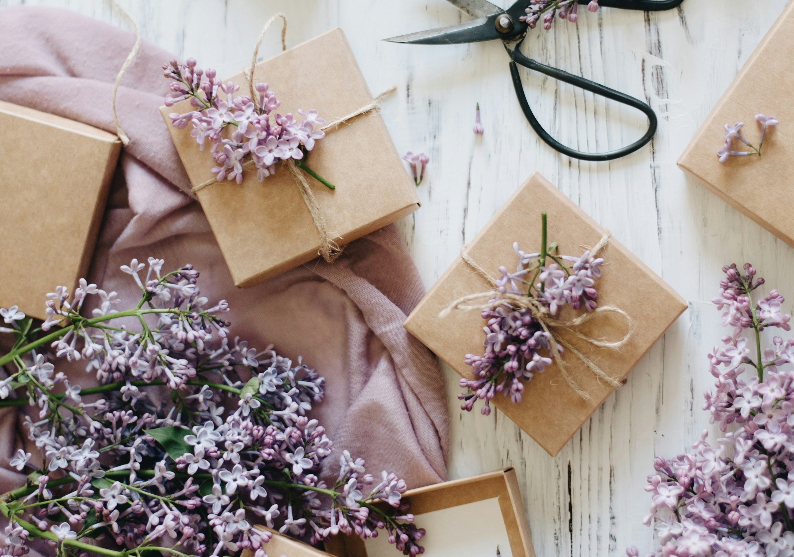 braune Geschenkeschachtel mit Blumen, Band und Schere