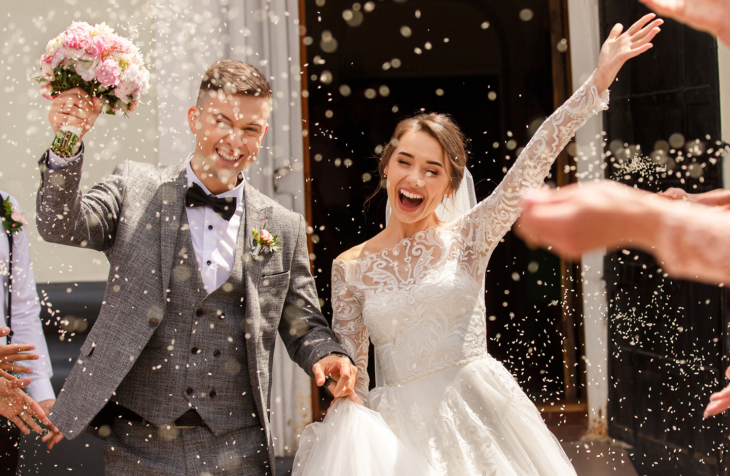 Brautpaar jubelt nach Hochzeit im Blüten-Konfettiregen ohne Hochzeitstauben