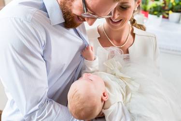 Junge Eltern mit Baby feiern Taufe