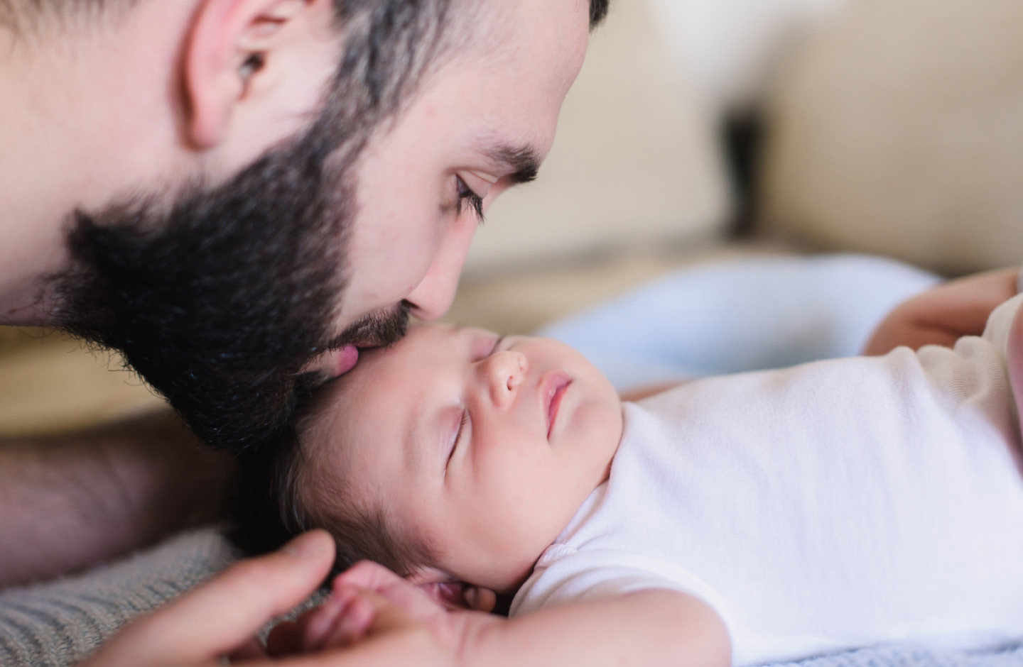 Vater küsst Baby auf den Kopf