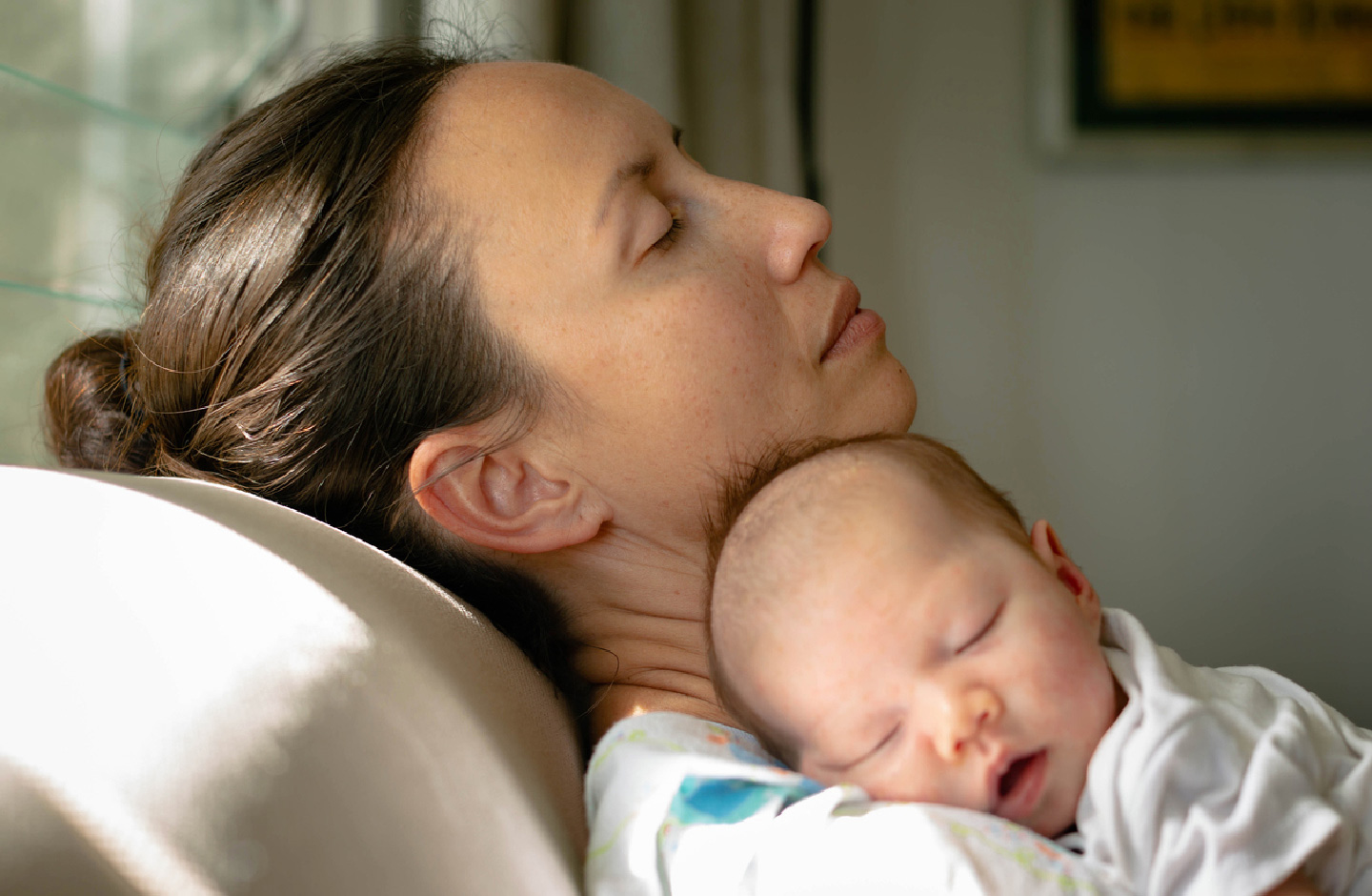 Erschöpfte Mutter mit ihrem schlafenden Baby 