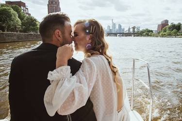 Hochzeitspaar in zärtlicher Pose in einem Boot auf dem Main 