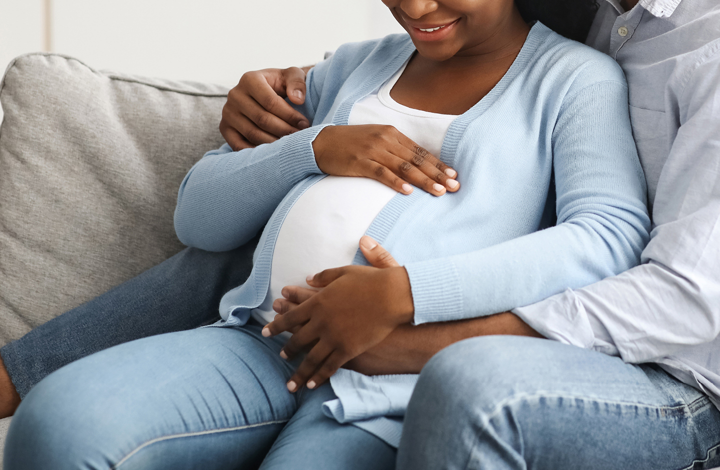 Zukünftiger Papa umarmt Mama mit Babybauch mit ersten Anzeichen für die Geburt.