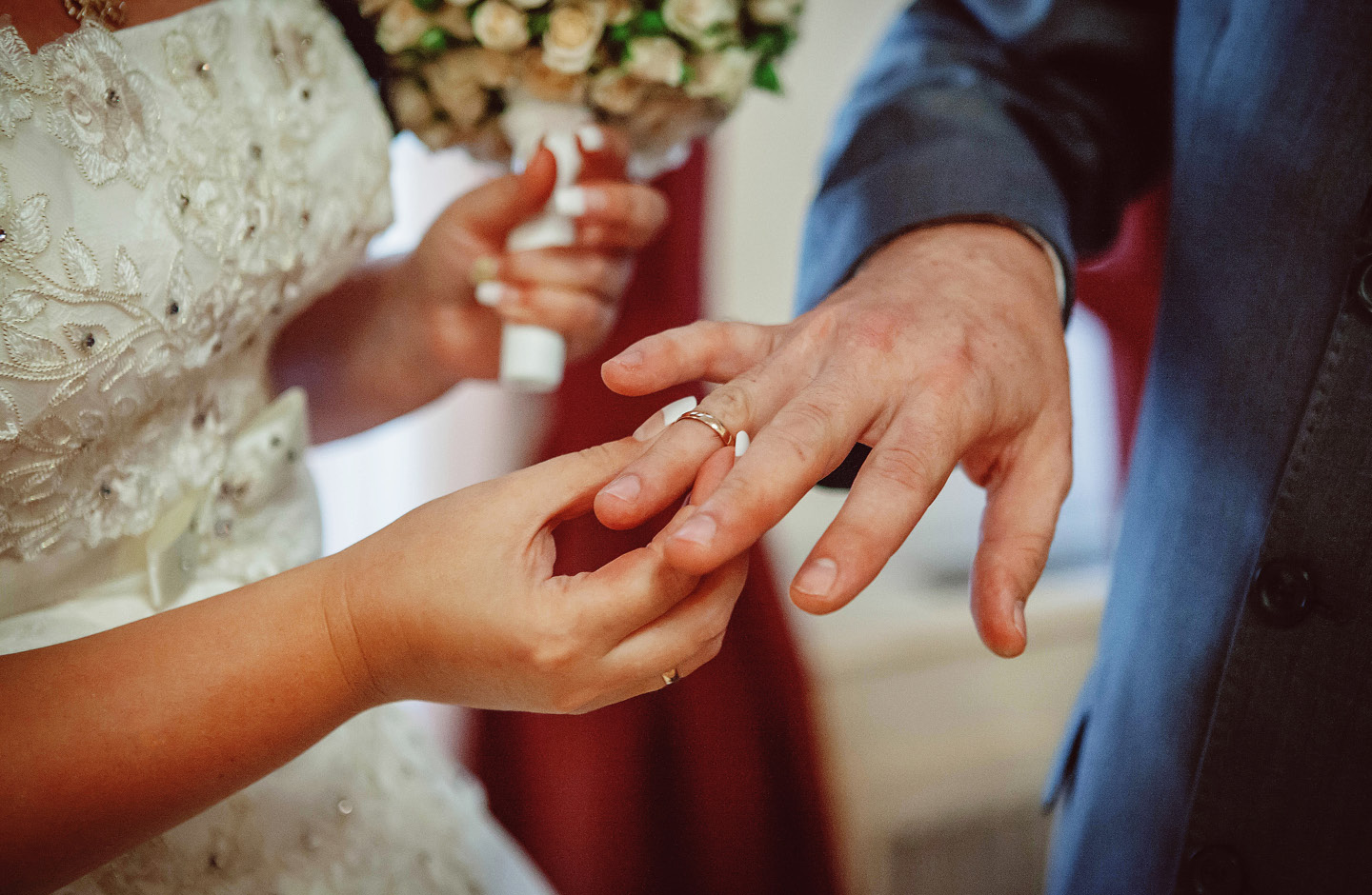 Braut steckt Bräutigam den Ring an