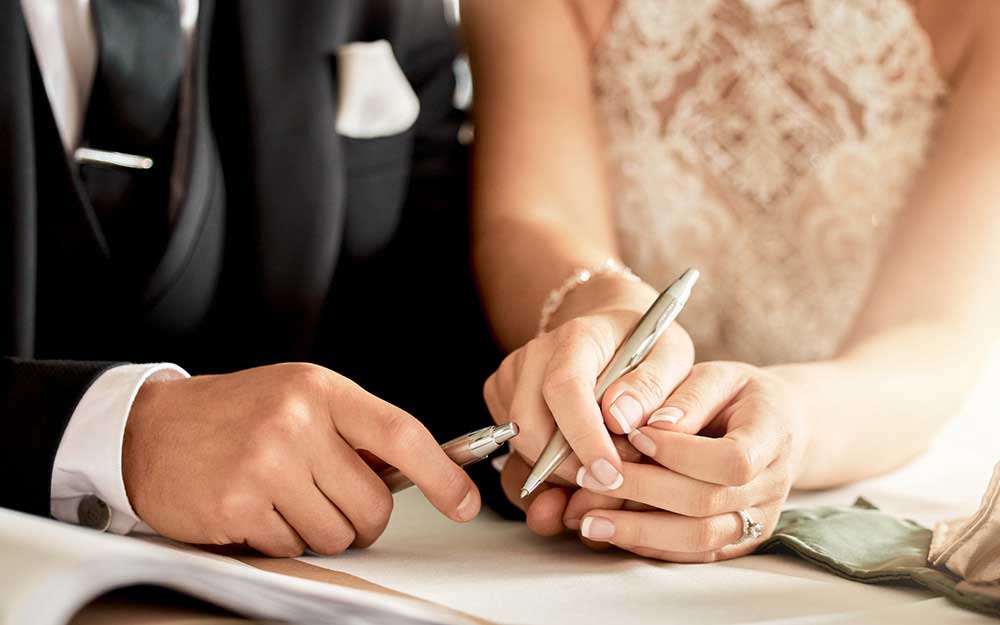 Paar unterschreibt Hochzeitsurkunde