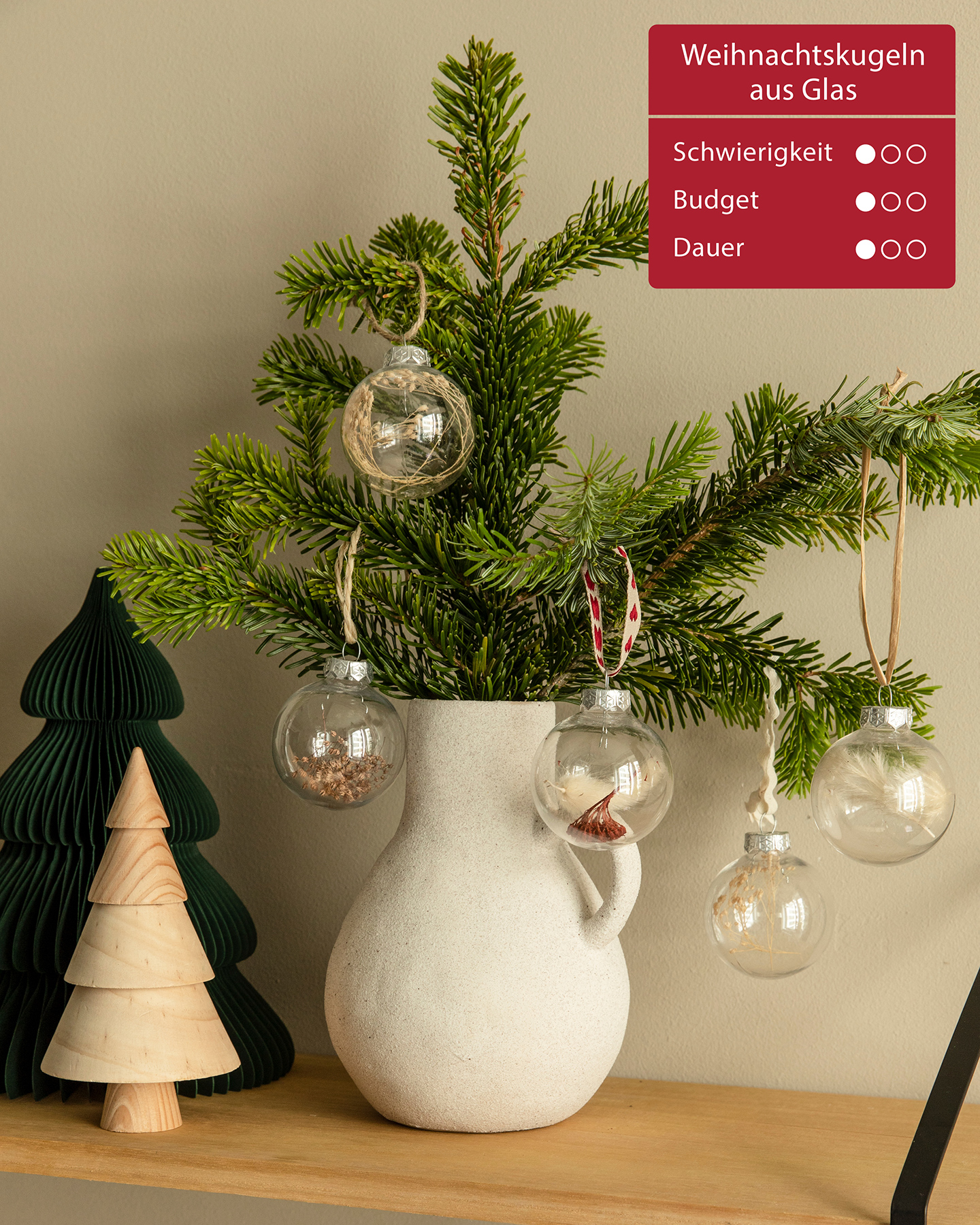 DIY-Weihnachtsbaumschmuck hängt an einem grünen Tannezweig.