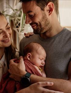 Glückliche Eltern, der Vater hält die neugeborene Tochter auf dem Arm