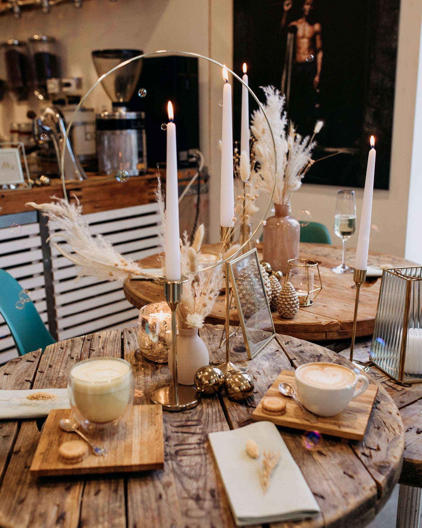Hochzeitstafel mit Goldelementen, Trockenblumen und weißen Kerzen dekoriert.