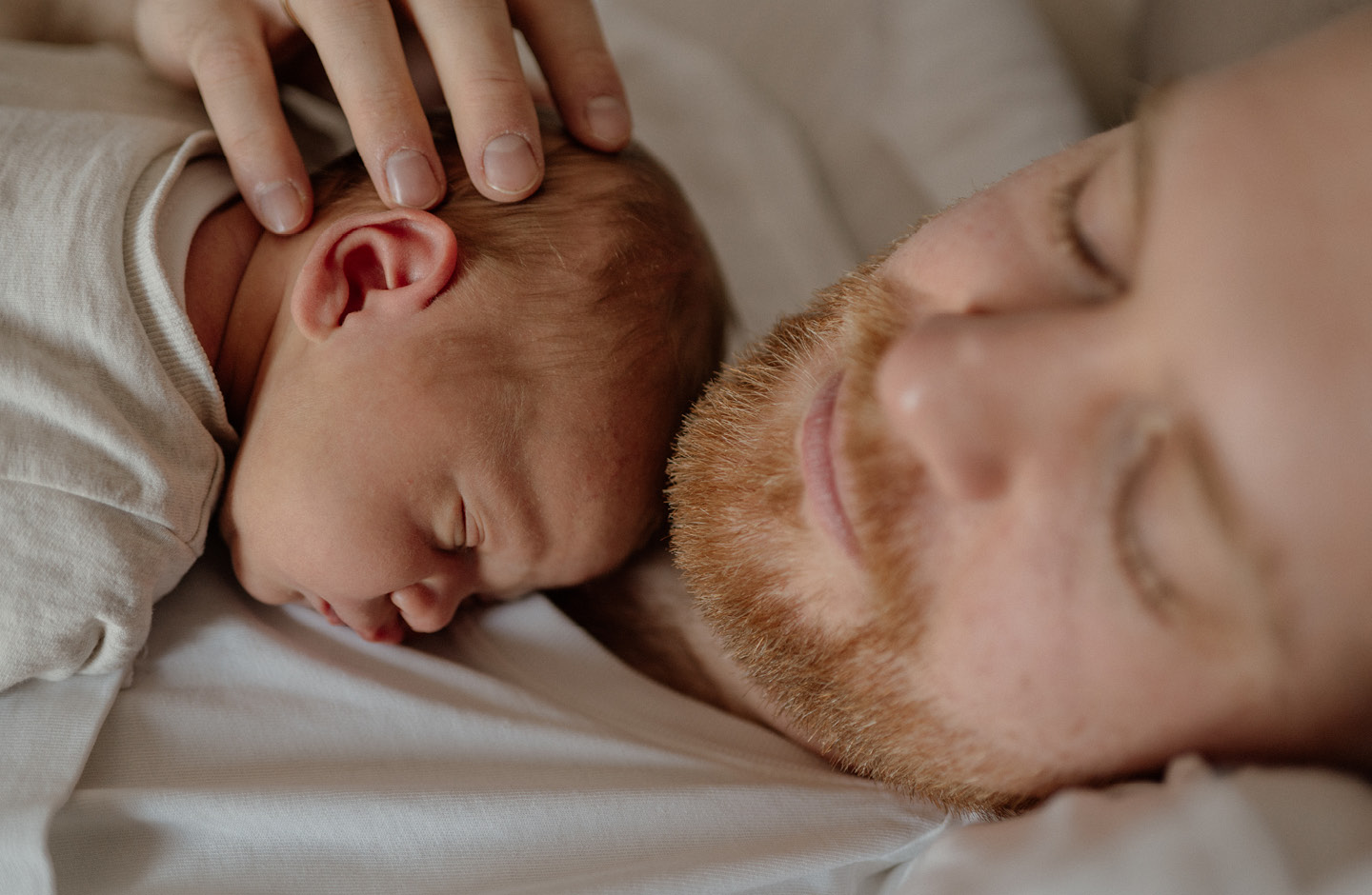 Glücklicher Vater kuschelt mit seinem Neugeborenen