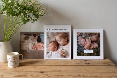 Drei Fotobücher auf einer Kommode nebeneinander aufgestellt
