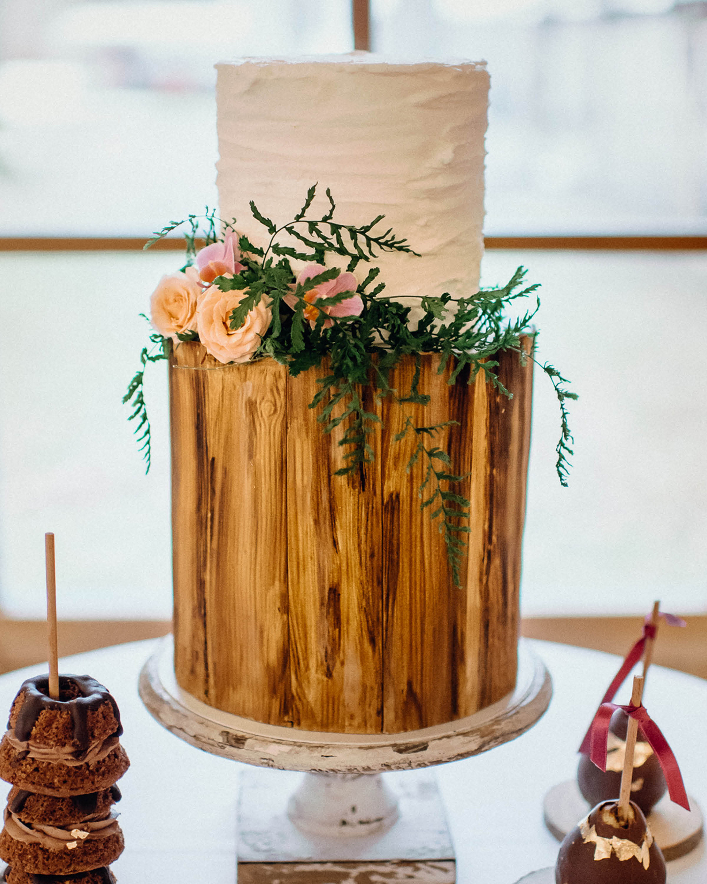 Hochzeitstorte mit Fondant im rustikalen Holz-Optik Stil. Verziert mit wilden Blumen und Pflanzen
