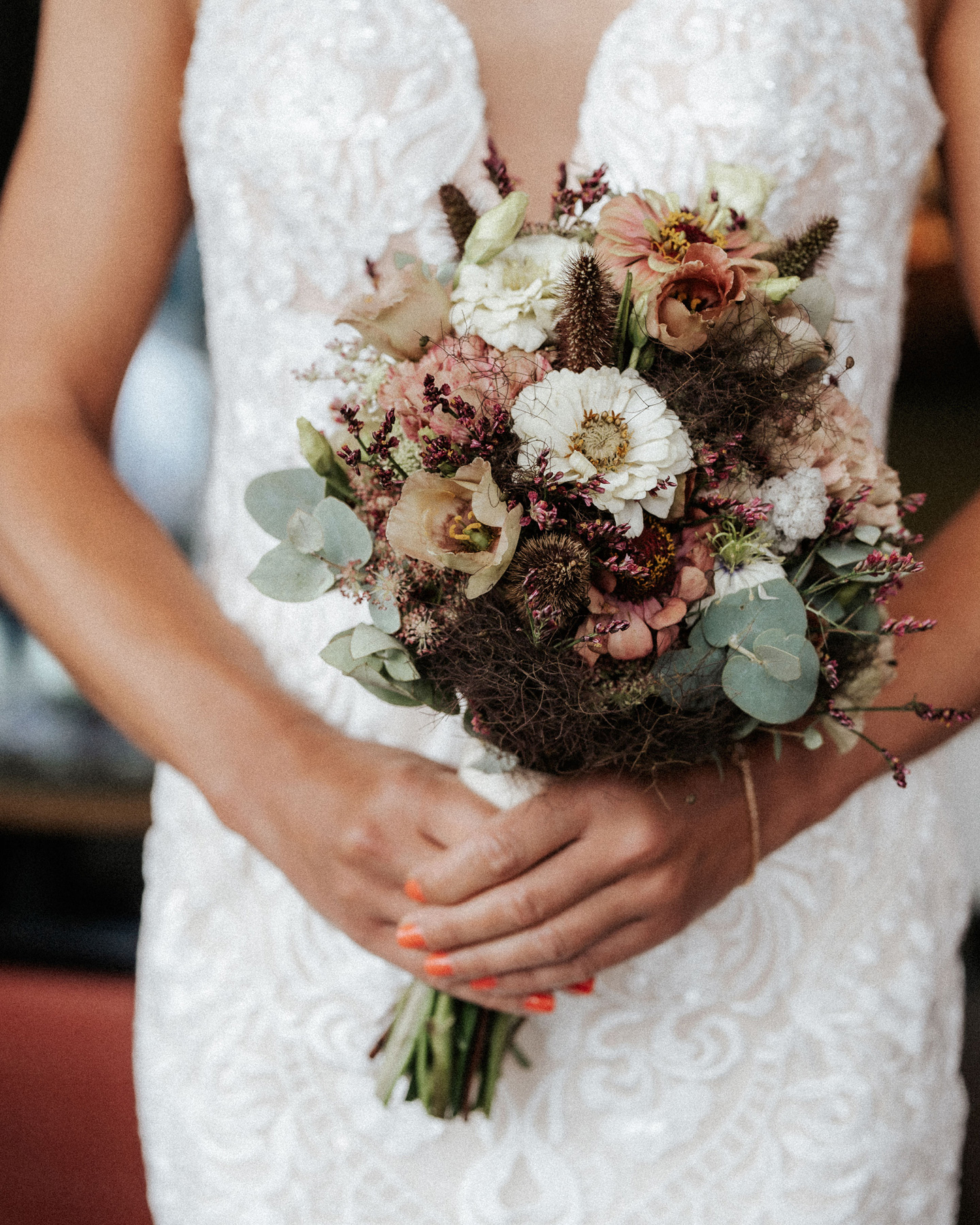 Bildausschnitt von Braut mit Brautstrauß in Rosétönen, Weiß und etwas Grün gebunden