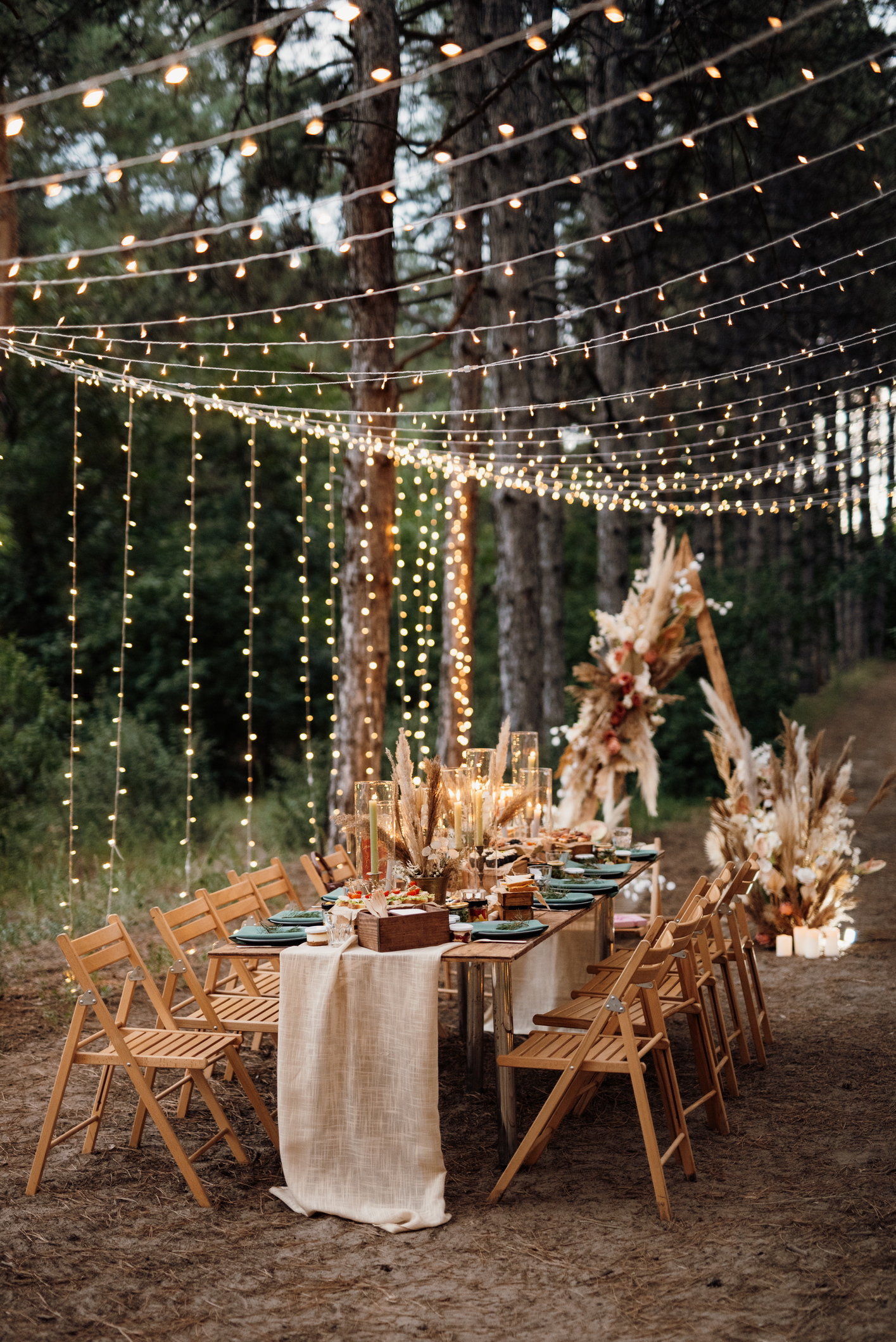 Eine Hochzeitstafel im Wald lädt zum Feiern ein.
