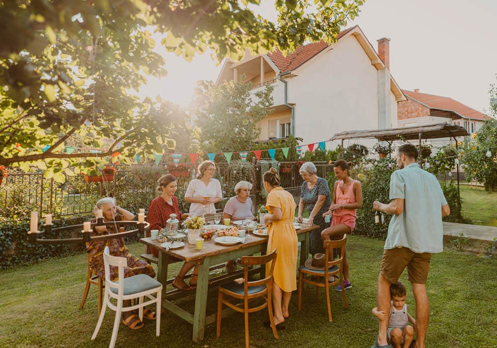 Familie feiert im Sommer das Namensgebungsfest des Kindes im Garten.