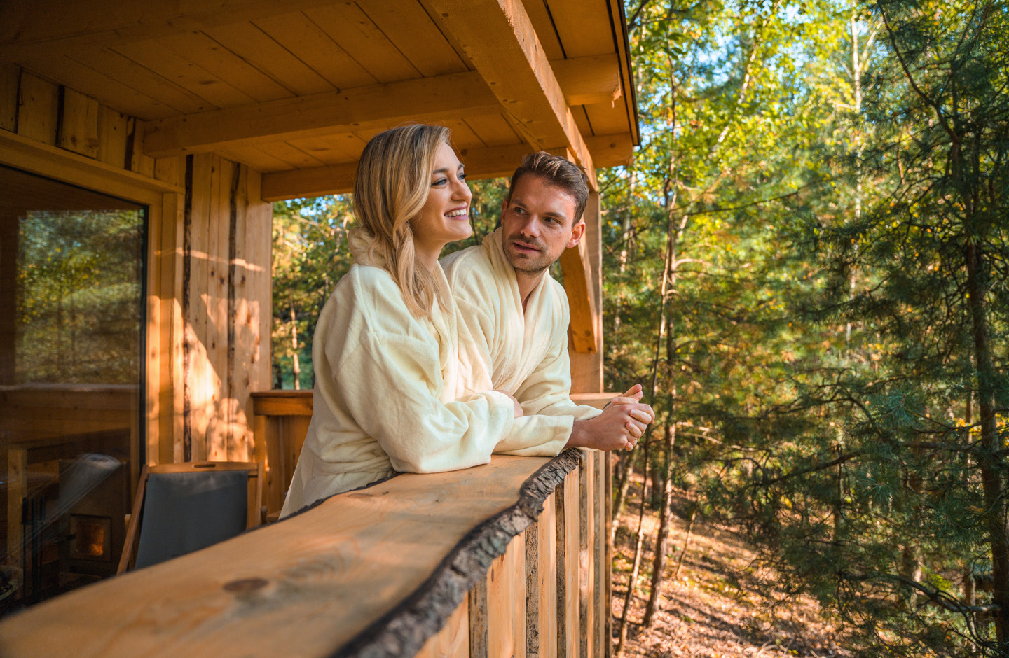 Paar steht auf Balkon eines Holzhauses  in der Natur