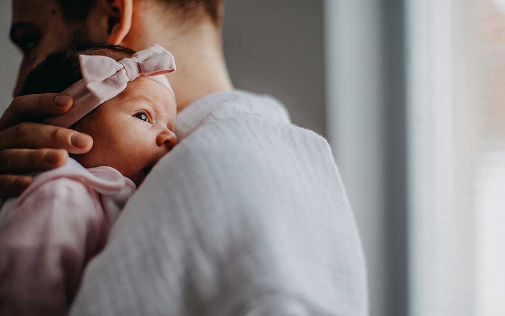 Vater hält Baby auf der Schulter