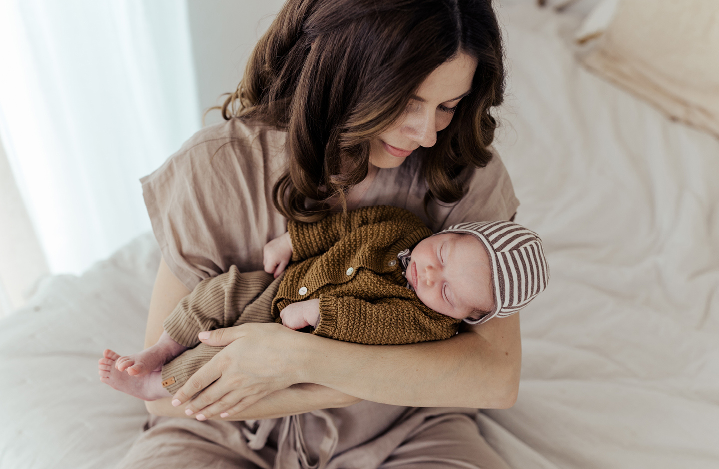 Mama hält ihr schlafendes Baby mit nordischem Mädchennamen "Lenja" auf dem Arm.