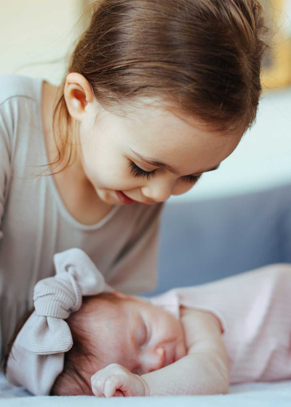Schwester bewundert neugeborenes Baby