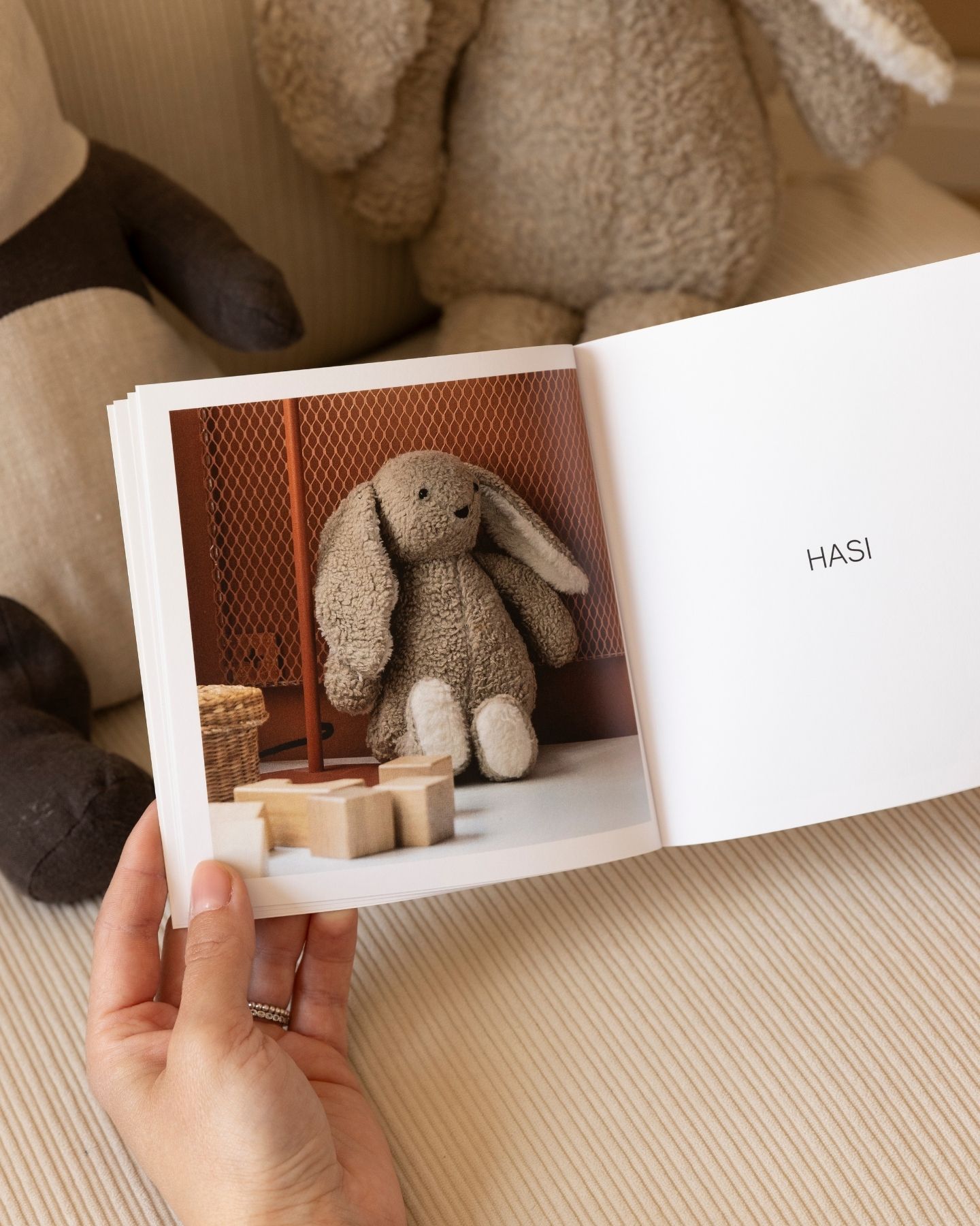 Innenseite eines Softcover Fotobuchs im quadratischen Format 15 x 15 cm. Links ein Bild eines Kuscheltierhasen, rechts steht geschrieben Hasi.