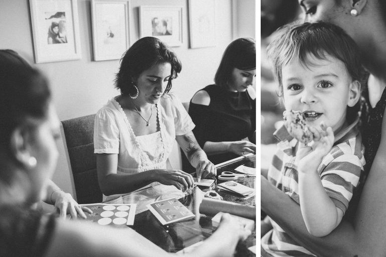 Alle haben Spaß am Gastgeschenke basteln, sowohl die Mütter, die konzentriert basteln als auch ein Kind, dass dabei ist und einen Keks isst. 