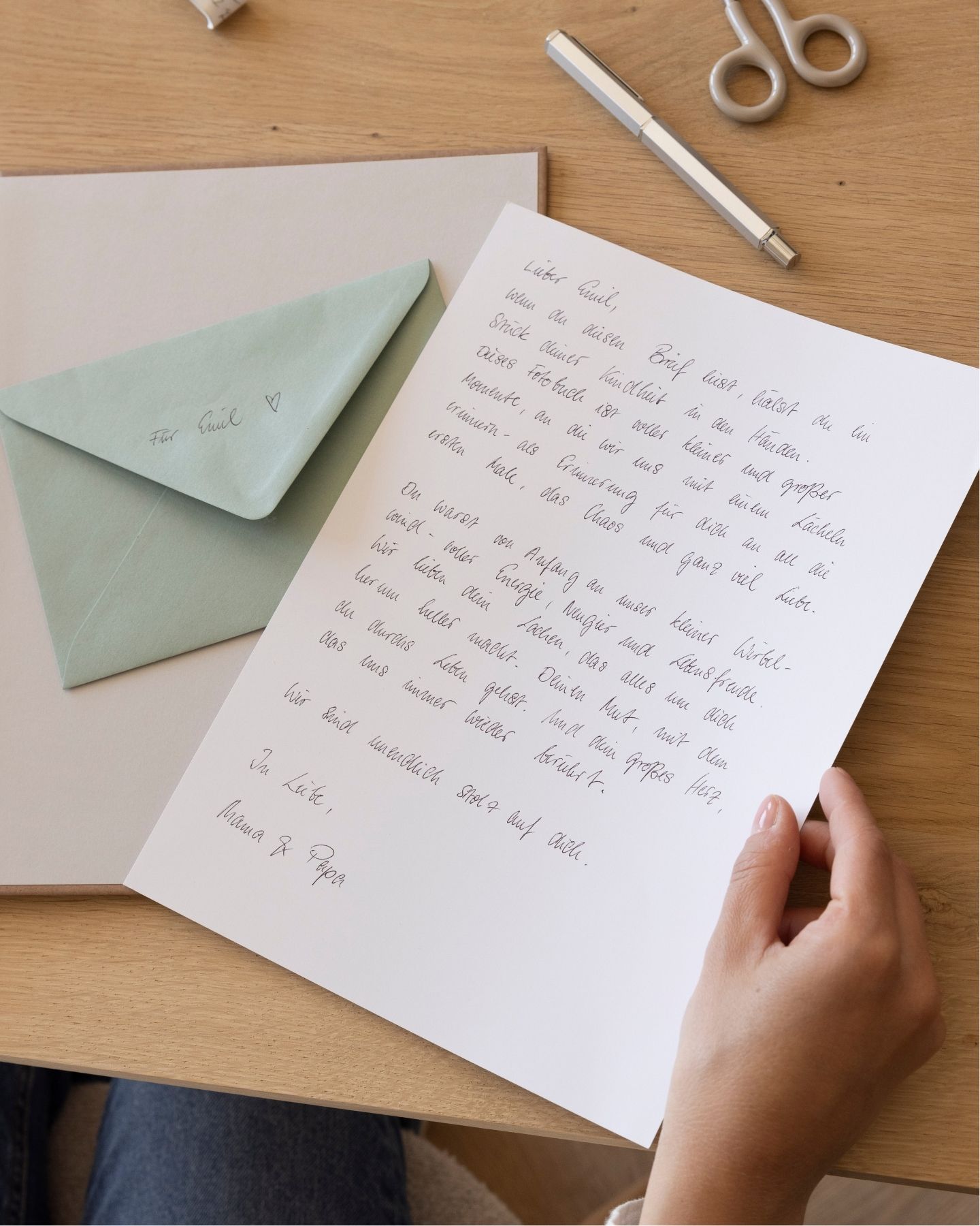 Erinnerungsalbum des Kindes mit Fotos auf der linken Seite und eingeklebten Erinnerungsstücken auf der rechten Seite: Persönlicher Brief an das Kind.