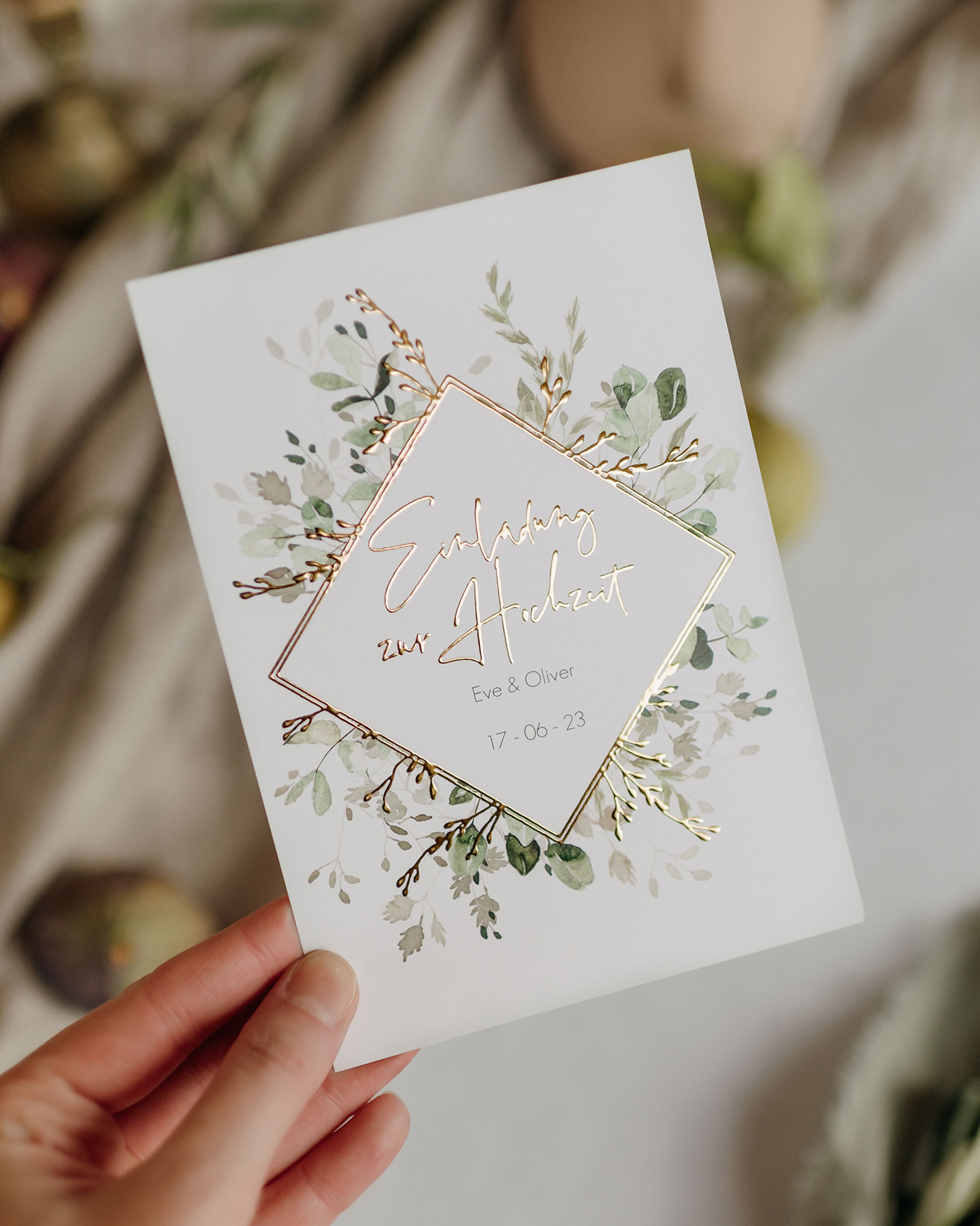 Die Hochzeitseinladung im Design Gold and Green macht ihrem Namen alle Ehre: Die goldene Veredelung umrahmt die handgezeichneten grünen Blätter.
