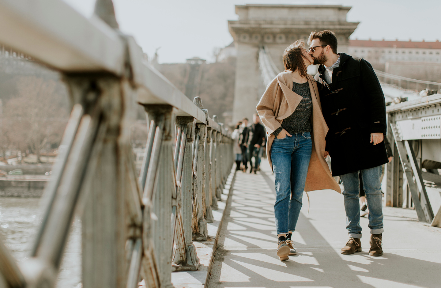 Liebespaar küsst sich auf einer Brücke