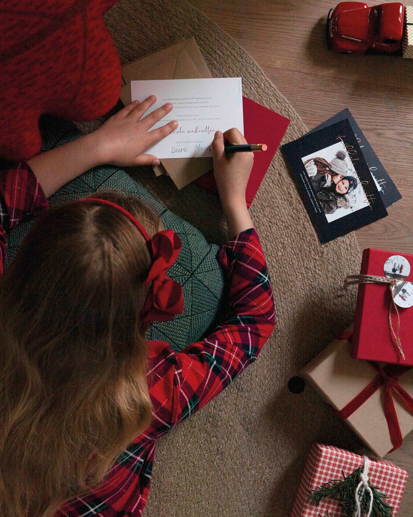 Mädchen schreibt Weihnachtsgedichte auf Karte