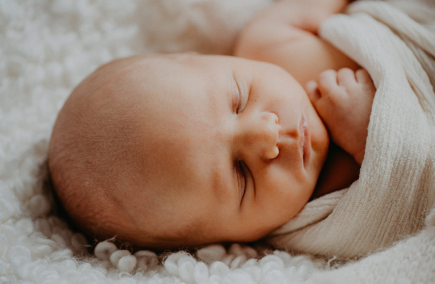 In eine Decke gehülltes Baby schlafend, Nahaufnahme des Kopfes