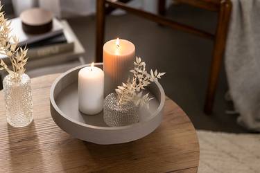 DIY Dekotablett aus Teller und Schale dekoriert mit Kerzen und einer kleinen Vase.
