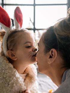 Ostersprüche: Tochter küsst Mutter an Ostern auf die Nase