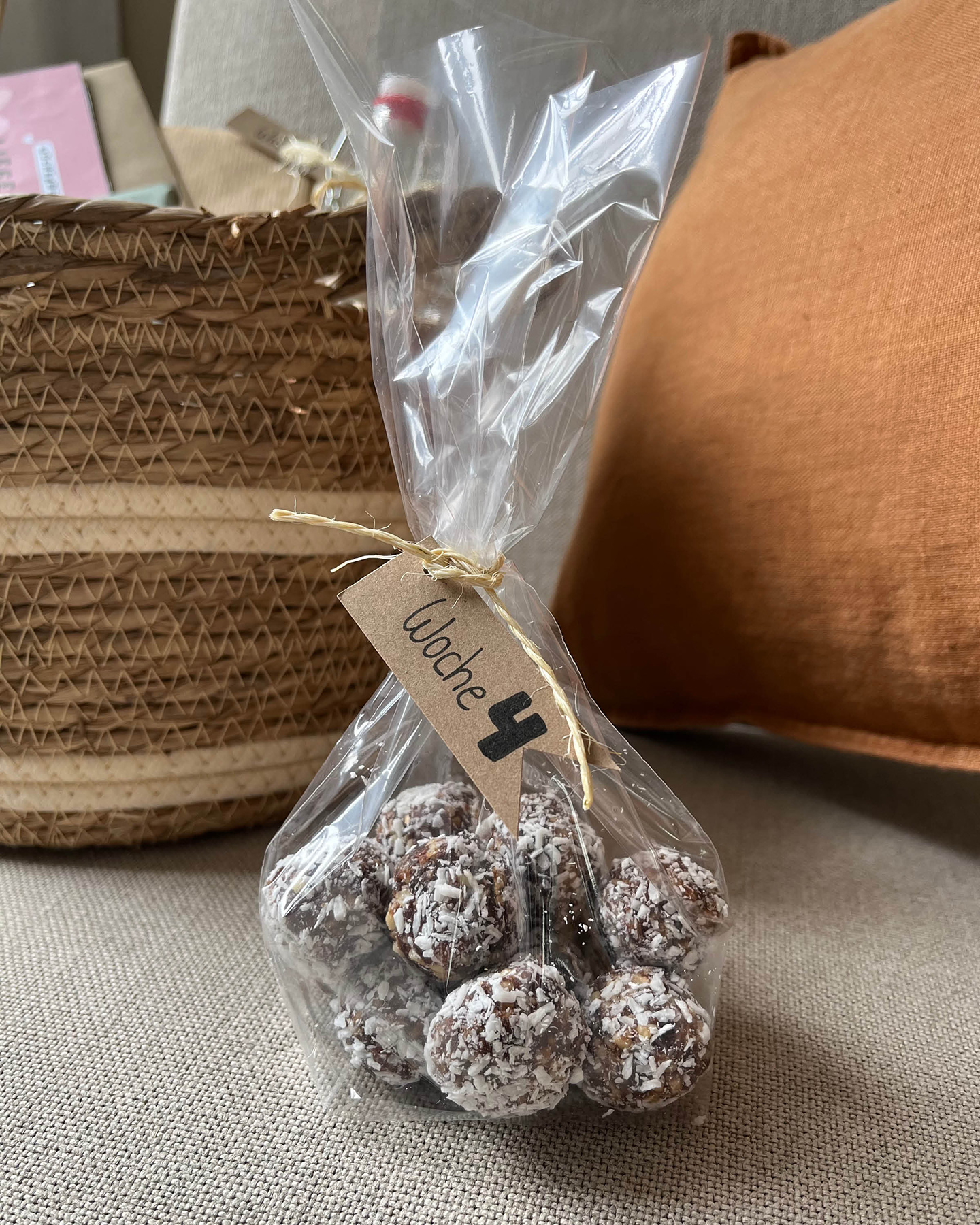 Selbst gemachte Energy Balls abgefüllt in einer Tüte. Selbst gemachter Wochenbettkalender als Geschenk zur Geburt für die Mutter. 