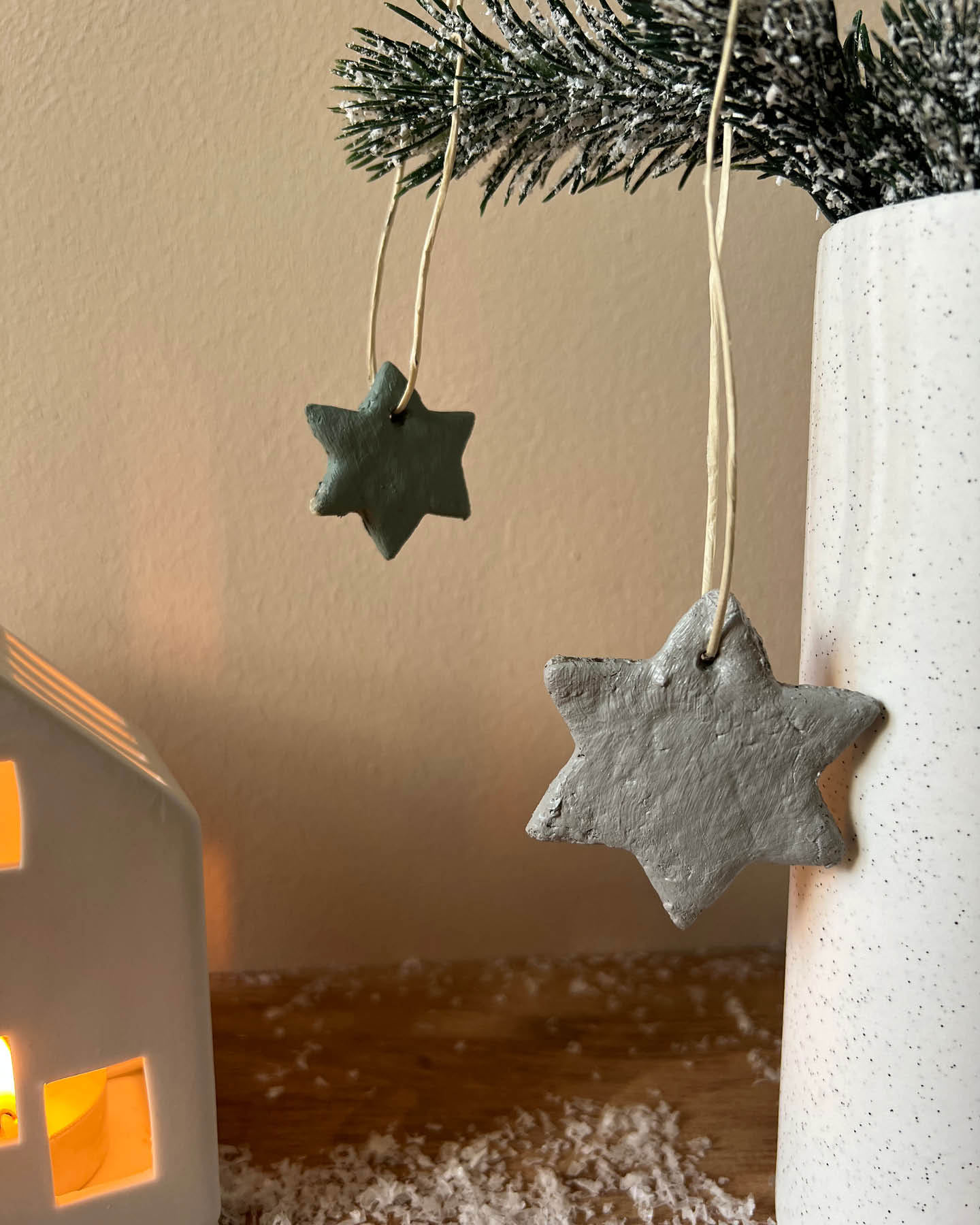 Stern aus Salzteig als Idee für den Weihnachtsbasar hängt an einem Tannenzweig.