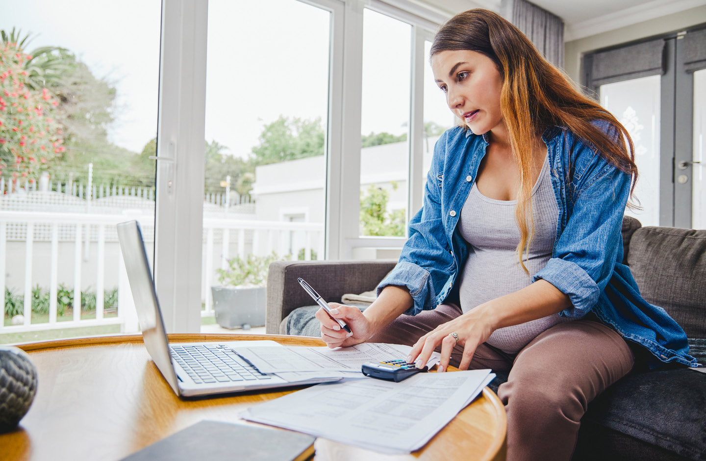 Schwangere mit Laptop prüft Schwangerschafts-Checkliste