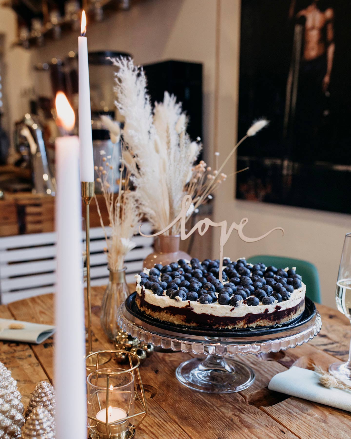 Hochzeitstorte mit Blaubeeren ist mit Love-Schild dekoriert zur Standesamtlichen Hochzeit in der Kaffeerösterei.