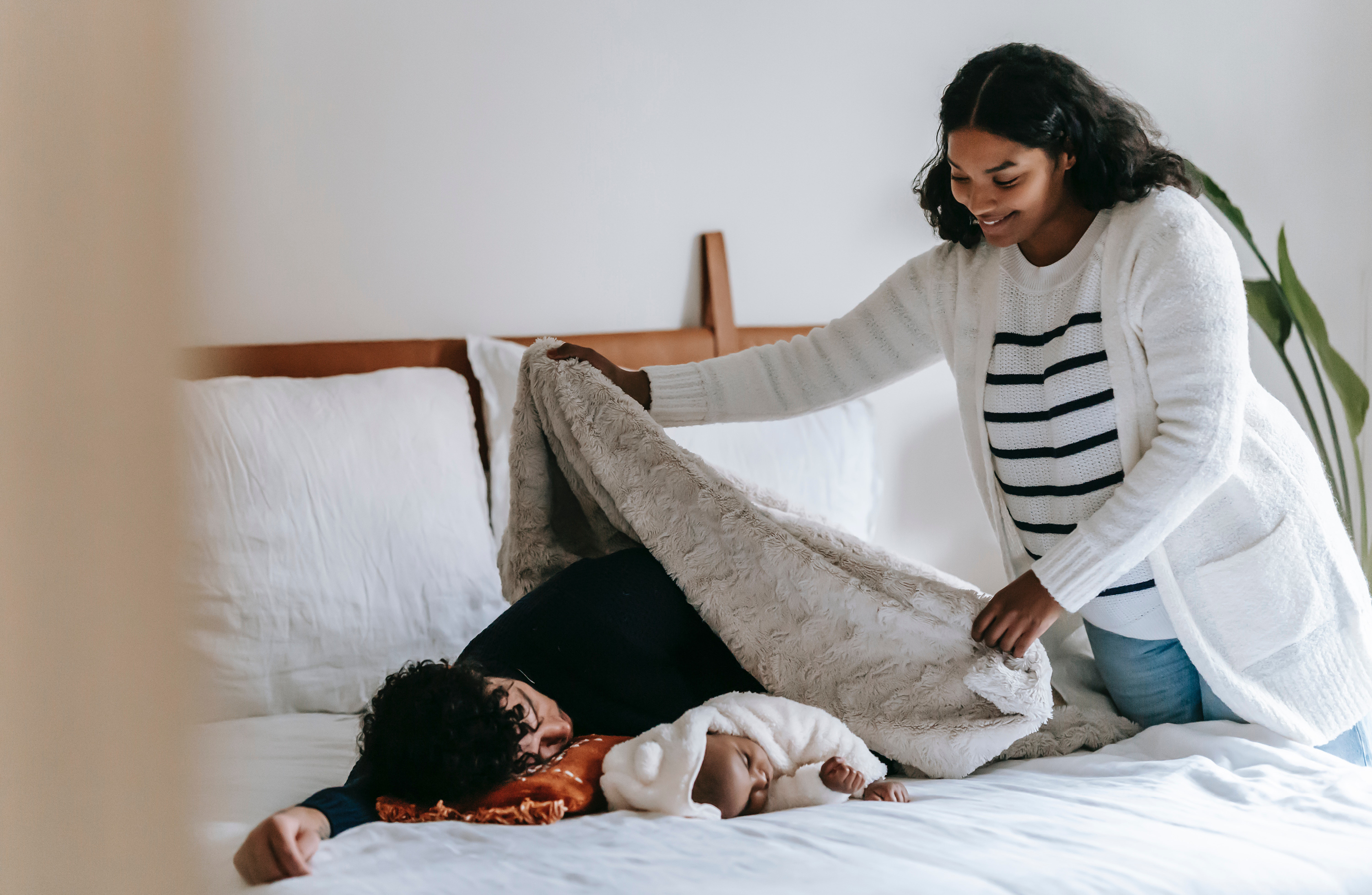 Vater und Baby werden von der Mama zugedeckt