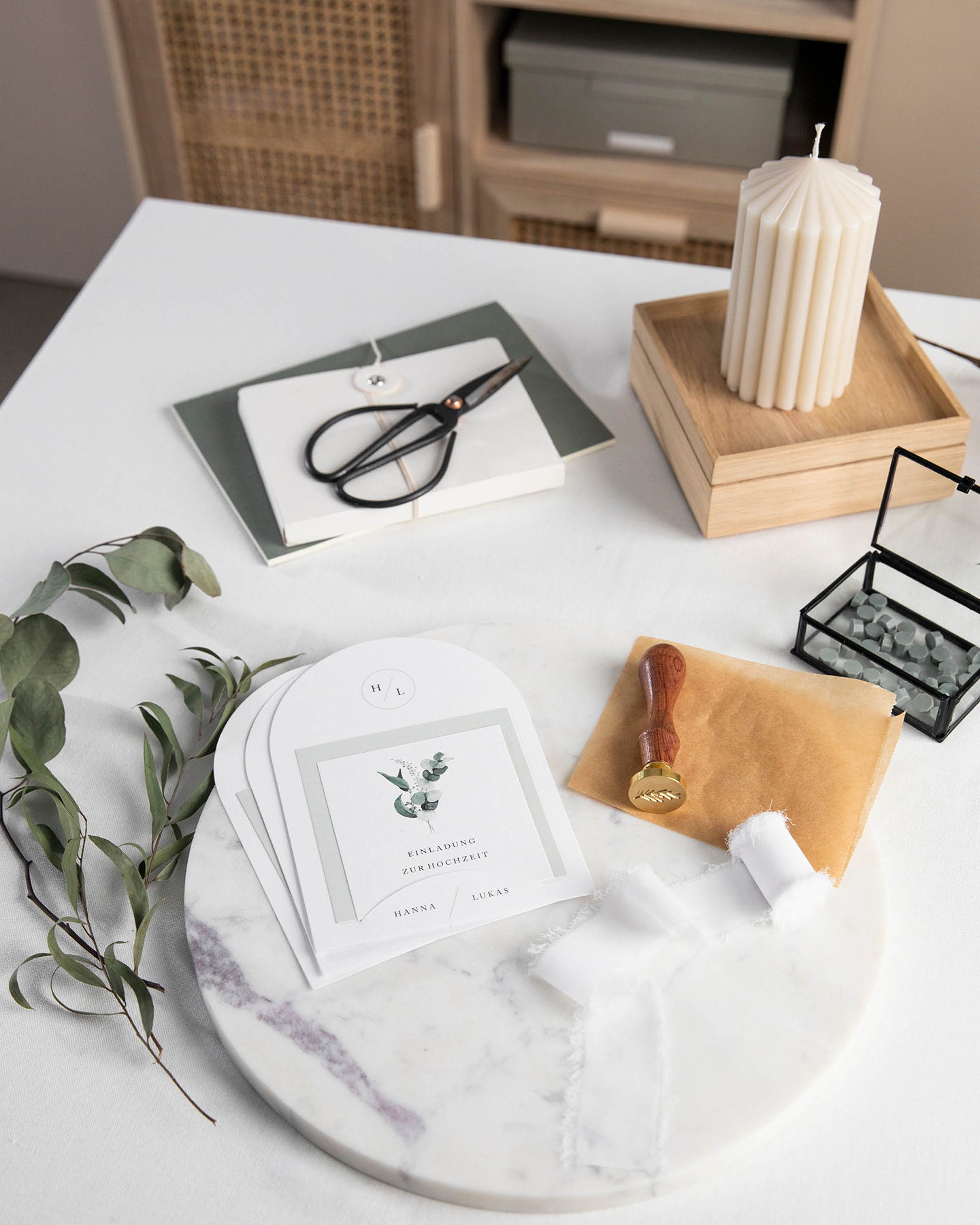 Materialien für DIY Hochzeitseinladung mit Wachssiegeln liegen auf dem Tisch.