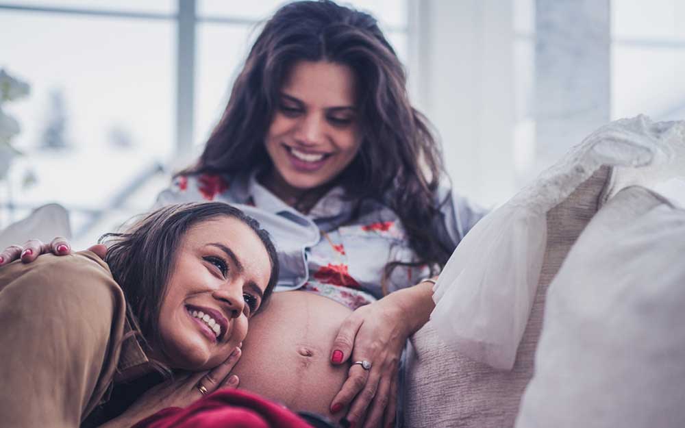 Zwei Frauen kuscheln auf Sofa