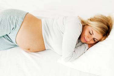 Schlafposition in der Schwangerschaft:Schwangere Frau im Bett