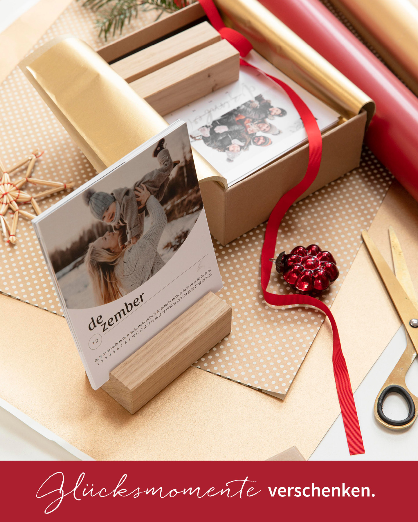 Fotokalender mit Holzfuß steht auf einem Holztisch und wird zu Weihnachten verpackt.