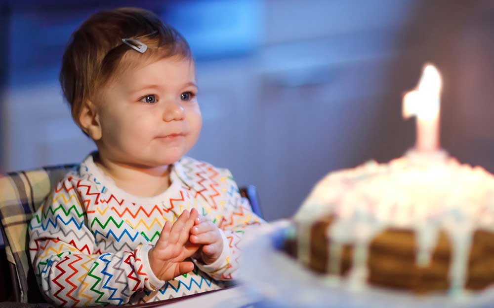 Baby mit Kuchen zu seinem ersten Geburtstag