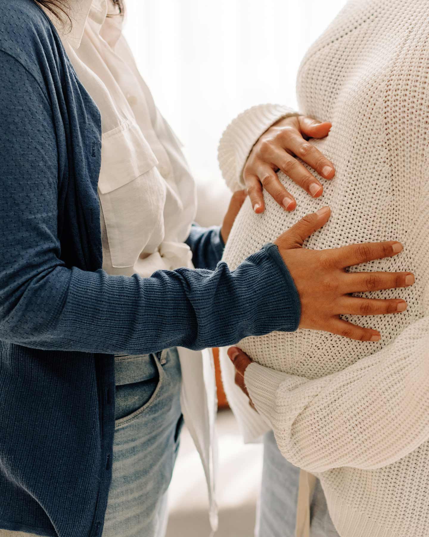 2 Trimester: Die Partnerin hält die Handy auf den Babybauch.