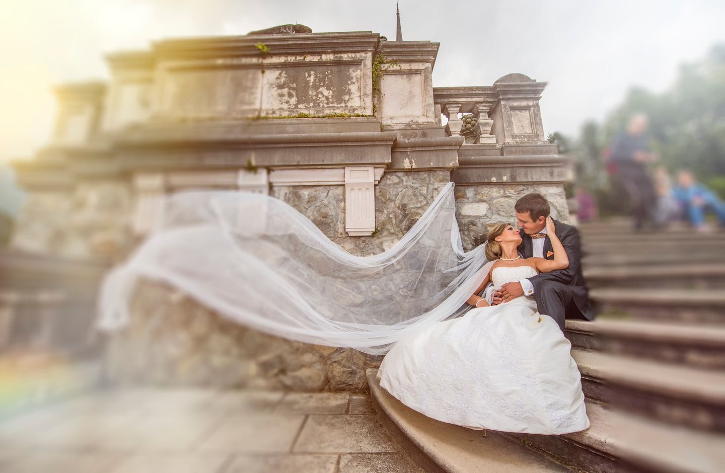 Brautpaar posiert nach der Hochzeit auf Steintreppe