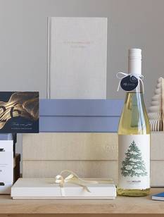 Weihnachtsgeschenke stehen auf einem Holztisch.